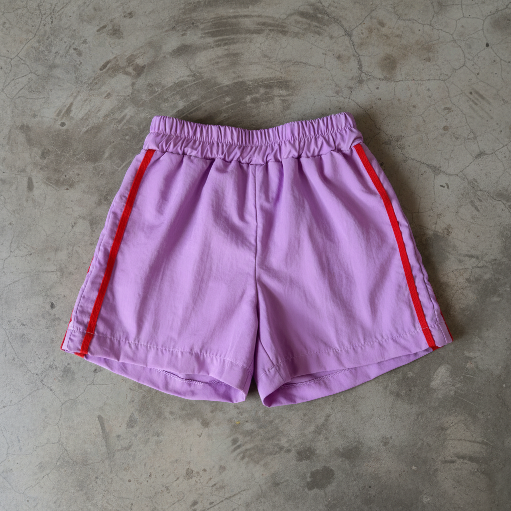 purple shorts with red accents on a concrete floor