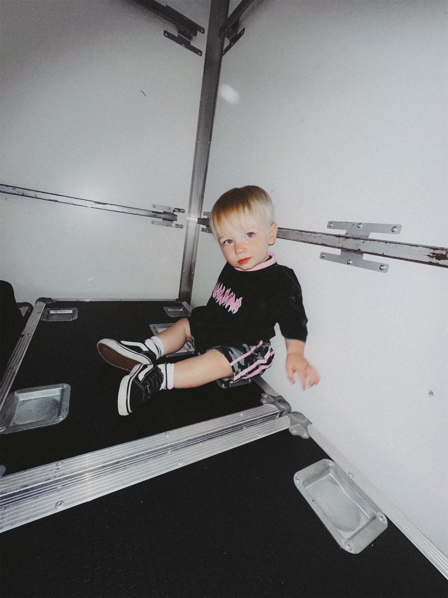 Child sitting on a roadcase