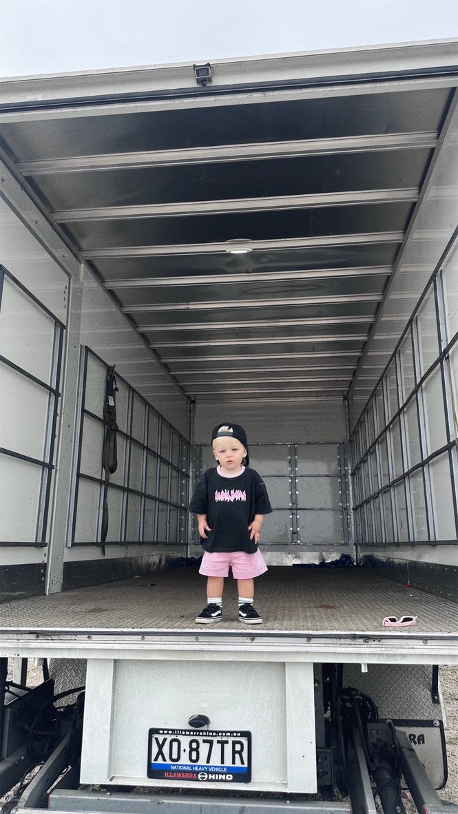 Child standing inside a large trailer with a visible license plate.